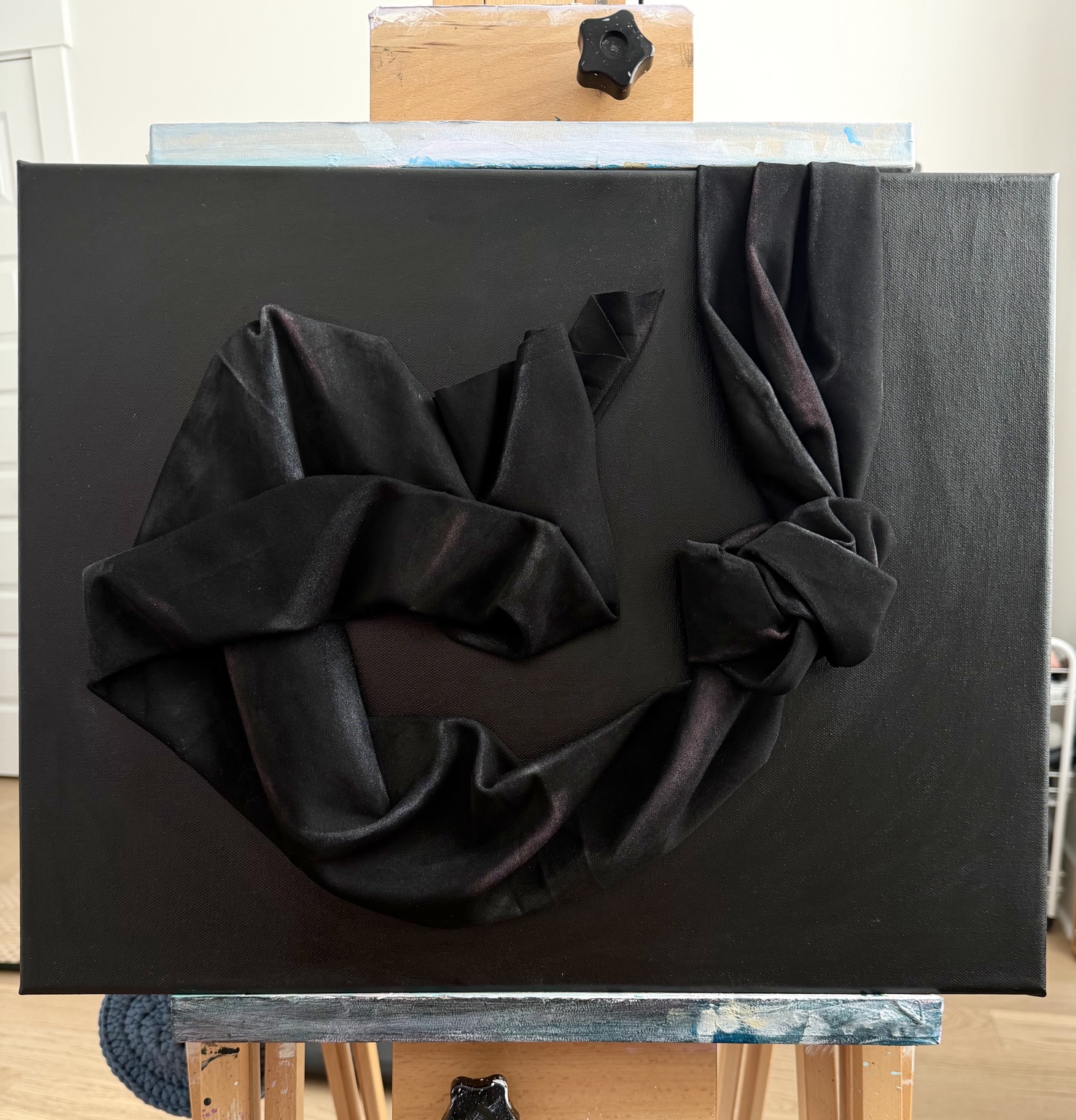 Eclipse, sculptural black fabric loops and folds on a black canvas