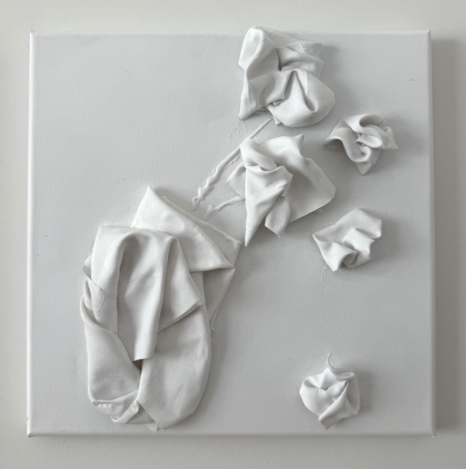 Present, Folded white fabric forms arranged across a white canvas